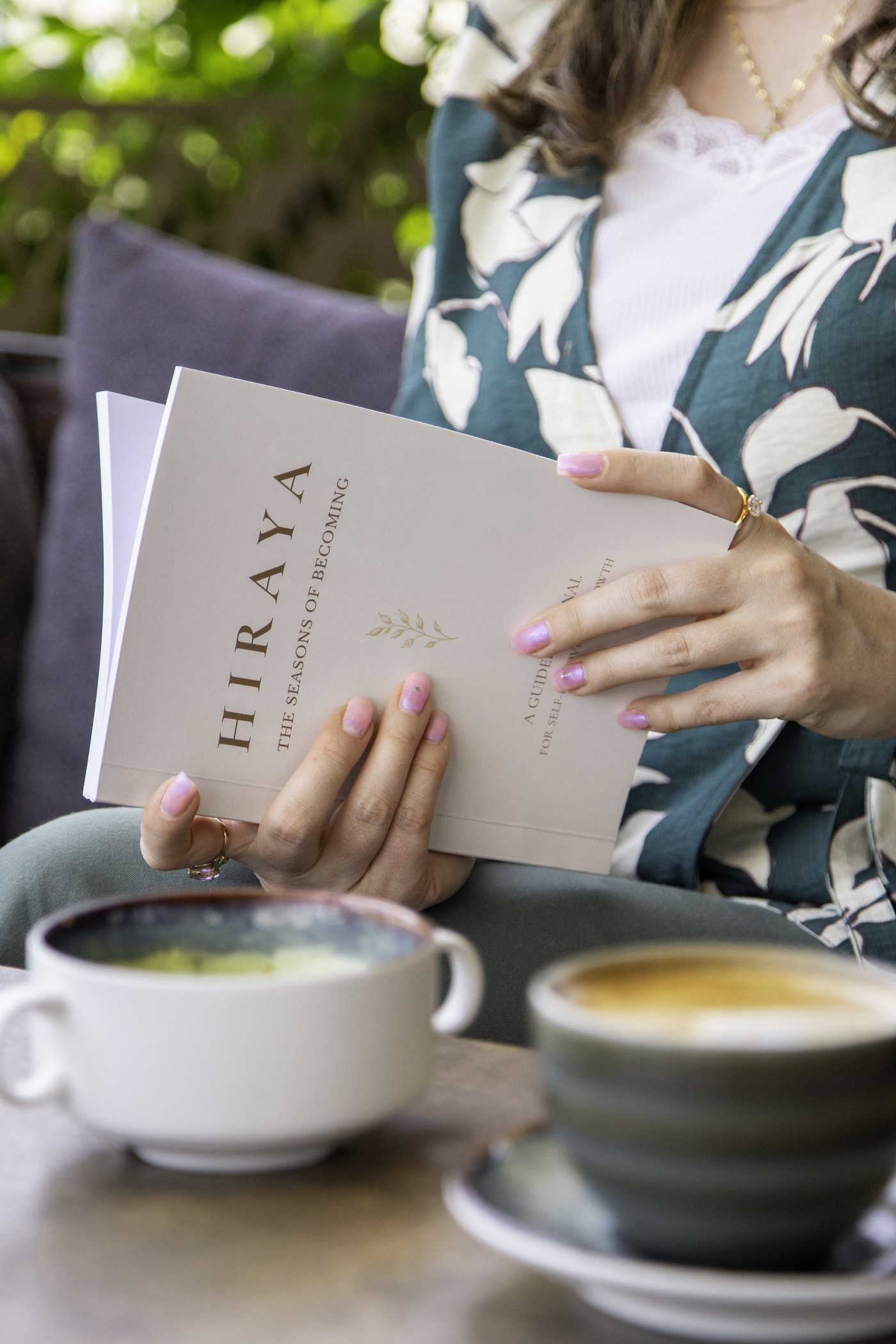 Woman holding HIRAYA The Seasons of Becoming guided journal